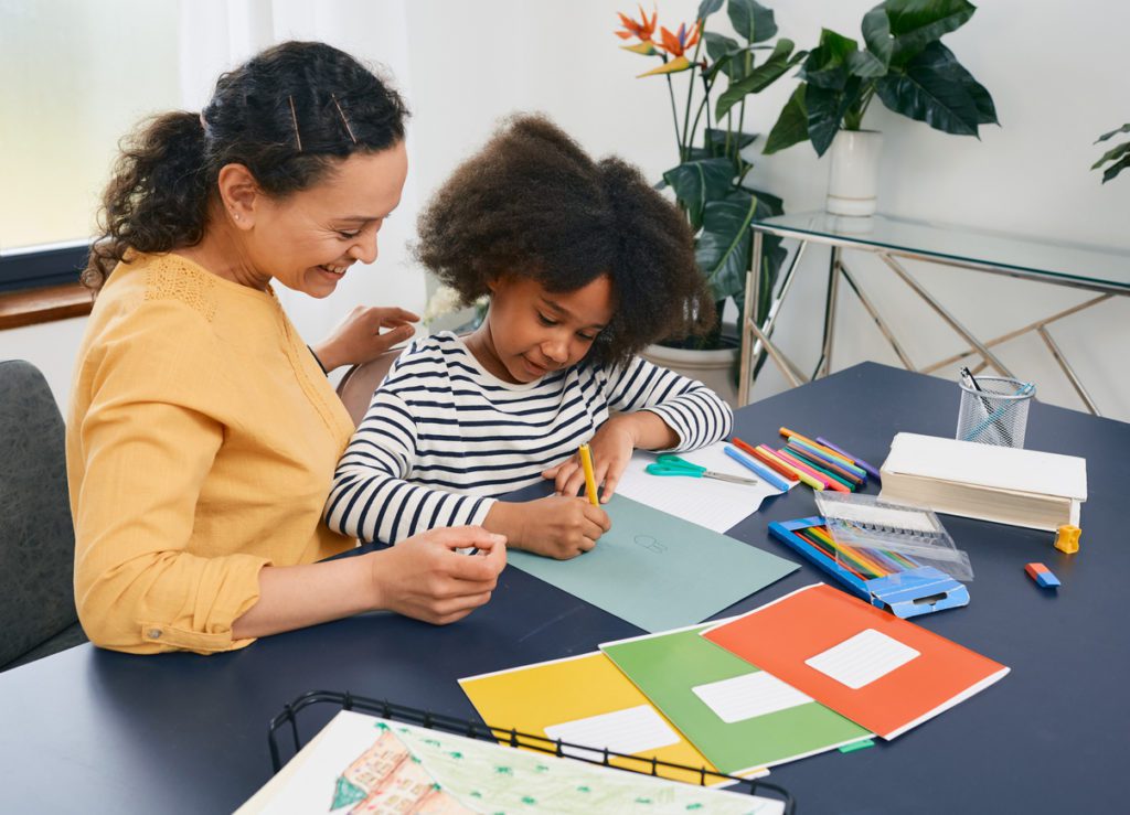 Parent and child learning at a desk demonstrating the importance of detecting the early signs of Autism